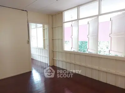 Bright room with wooden floors and large windows, perfect for a cozy living space.
