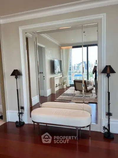 Luxurious living room with city view, elegant decor, and hardwood floors