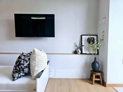 Modern living room with wall-mounted TV, stylish decor, and cozy seating area.