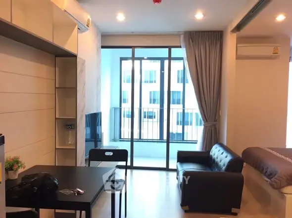 Modern studio apartment with balcony and sleek furnishings