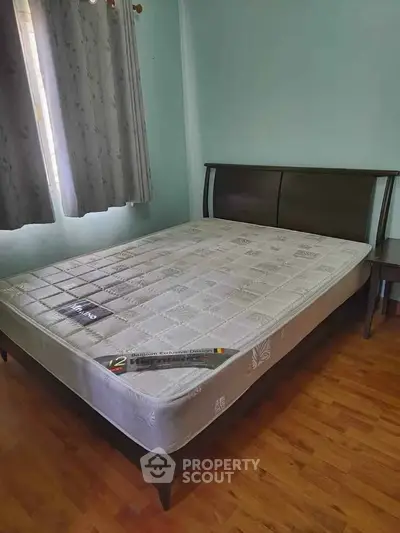 Cozy bedroom with a comfortable bed and wooden flooring, perfect for relaxation.