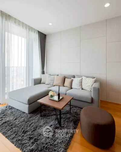 Modern living room with stylish gray sofa and chic decor in a bright apartment.