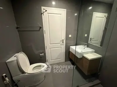 Modern bathroom with sleek design featuring a glass shower and contemporary fixtures.