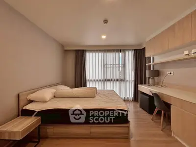 Modern bedroom with sleek furniture and natural light, perfect for a cozy retreat.
