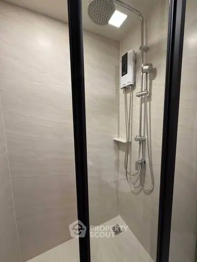 Modern shower area with sleek fixtures and neutral tiles in a contemporary bathroom.