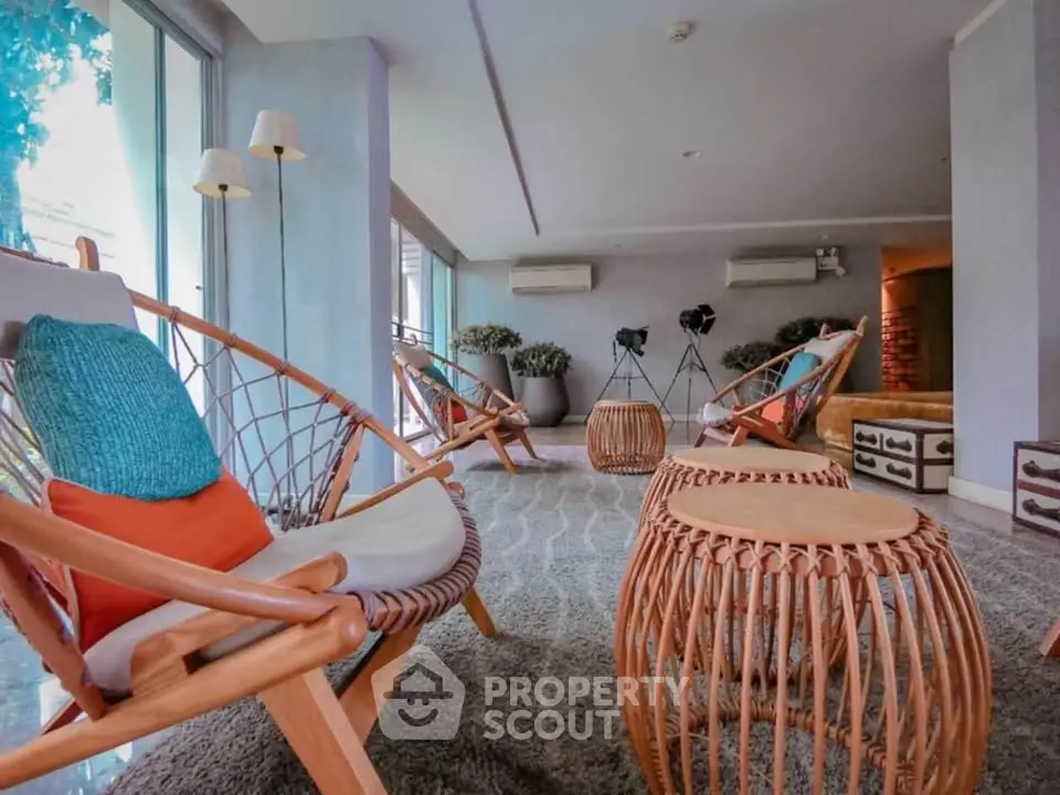 Stylish living room with modern wicker furniture and large windows