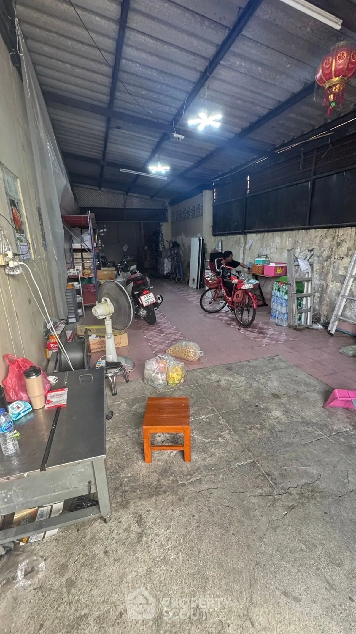 Spacious storage area with concrete floor, bicycles, and shelving units.