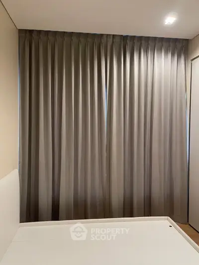 Cozy bedroom with elegant curtains and minimalist design, perfect for relaxation.