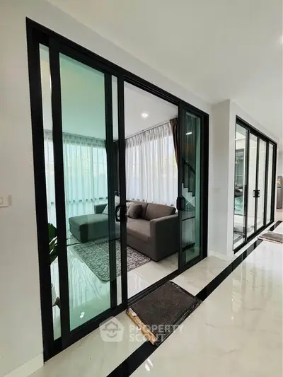Modern living room with glass sliding doors and elegant interior design.