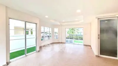 Spacious and bright living room with large windows and modern flooring.