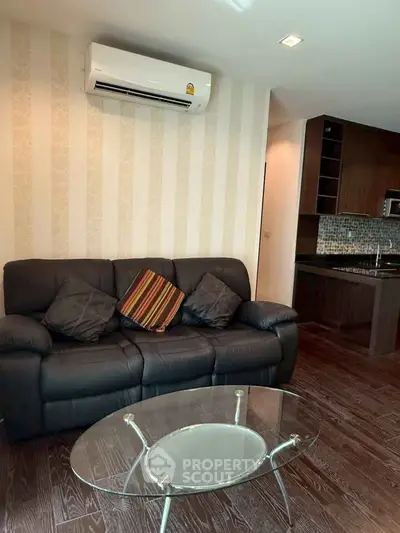 Stylish living room with modern sofa and open kitchen layout.