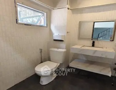 Modern bathroom with sleek fixtures and large mirror in a contemporary home.