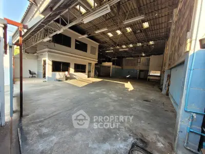 Spacious industrial warehouse with high ceilings and ample natural light.