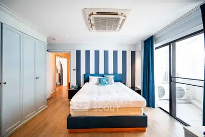 Spacious modern bedroom with balcony access and stylish decor