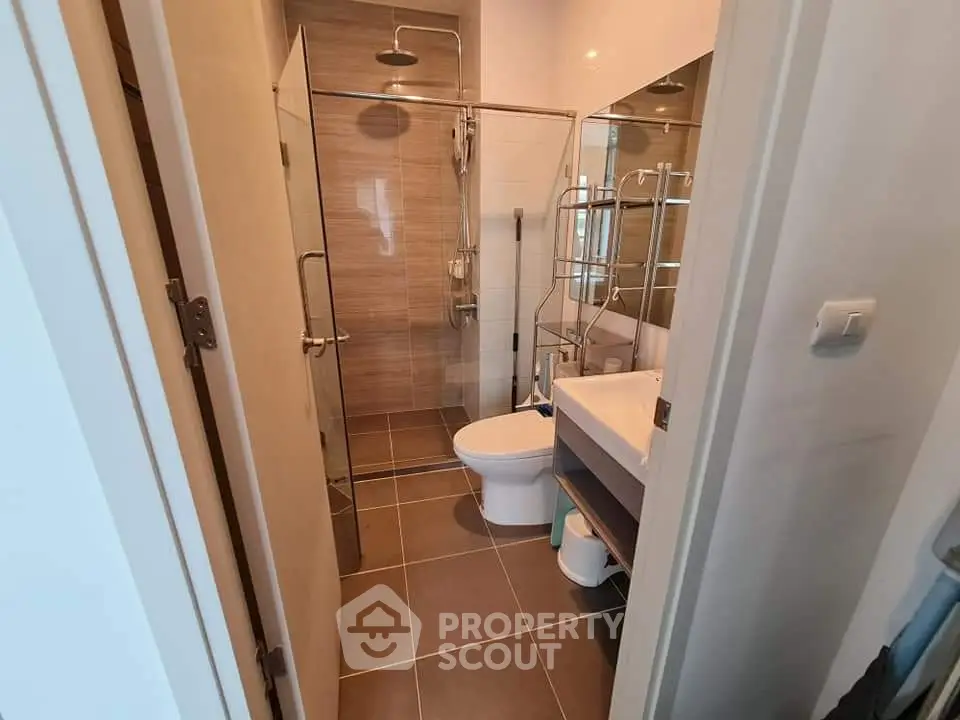 Modern bathroom with glass shower and sleek fixtures in a contemporary apartment.