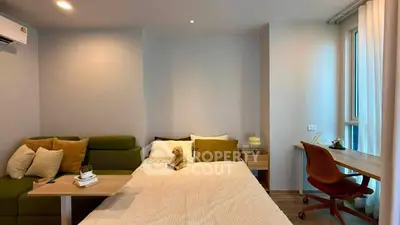 Modern bedroom with cozy bed, stylish sofa, and work desk in bright apartment.