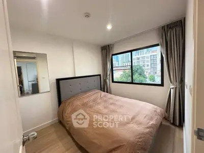Cozy bedroom with large window offering city view, featuring modern decor and ample natural light.