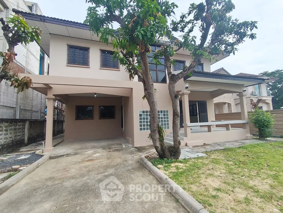 Charming two-story house with spacious driveway and lush greenery, perfect for family living.