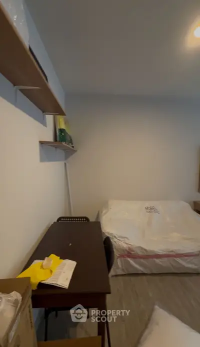 Cozy bedroom with modern shelves and a neatly made bed, ideal for comfortable living.