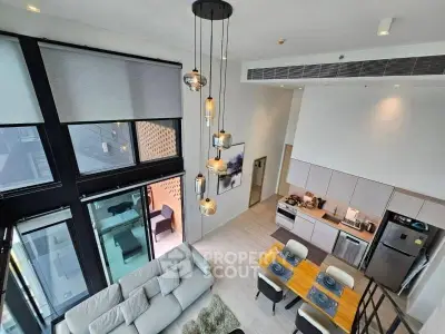 Modern open-plan living room with high ceilings and stylish lighting