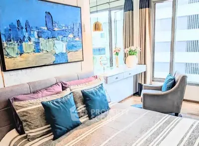 Modern bedroom with stylish decor and large windows offering natural light.