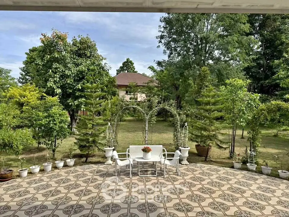 Charming garden view with elegant patio seating and lush greenery, perfect for outdoor relaxation and entertaining.