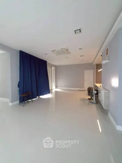 Spacious modern living room with sleek flooring and large windows