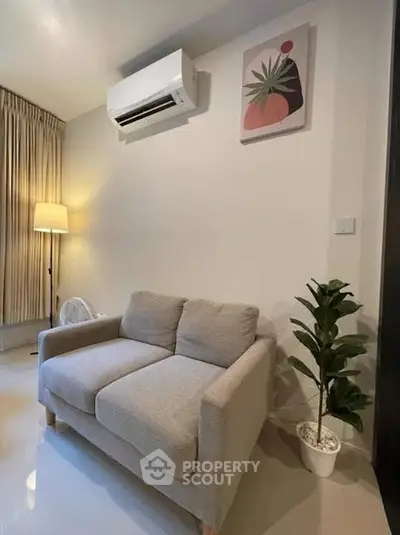 Cozy living room with modern sofa, air conditioning, and stylish decor