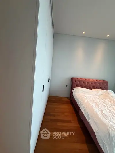 Spacious bedroom with elegant pink headboard and ample closet space