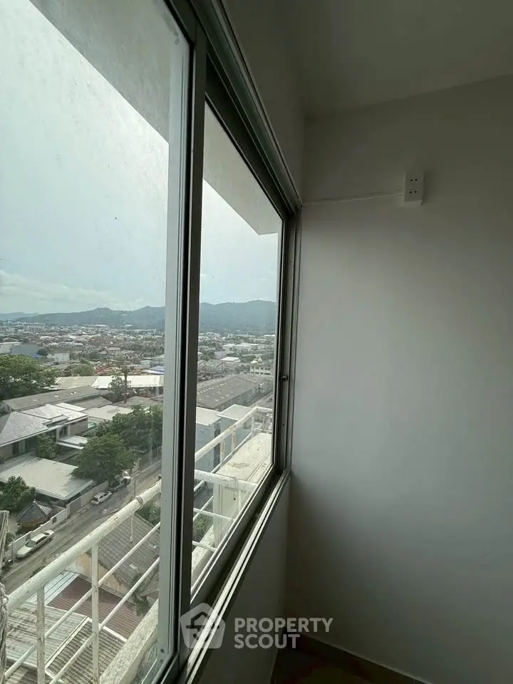 High-rise apartment view with expansive cityscape and mountain backdrop, showcasing urban living with scenic vistas.