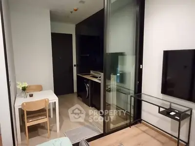 Modern compact living room with open kitchen and sleek glass partition
