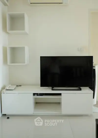 Modern living room with sleek TV stand and wall-mounted shelves, perfect for minimalist decor.