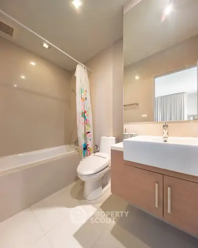 Modern bathroom with bathtub and sleek vanity in contemporary apartment.
