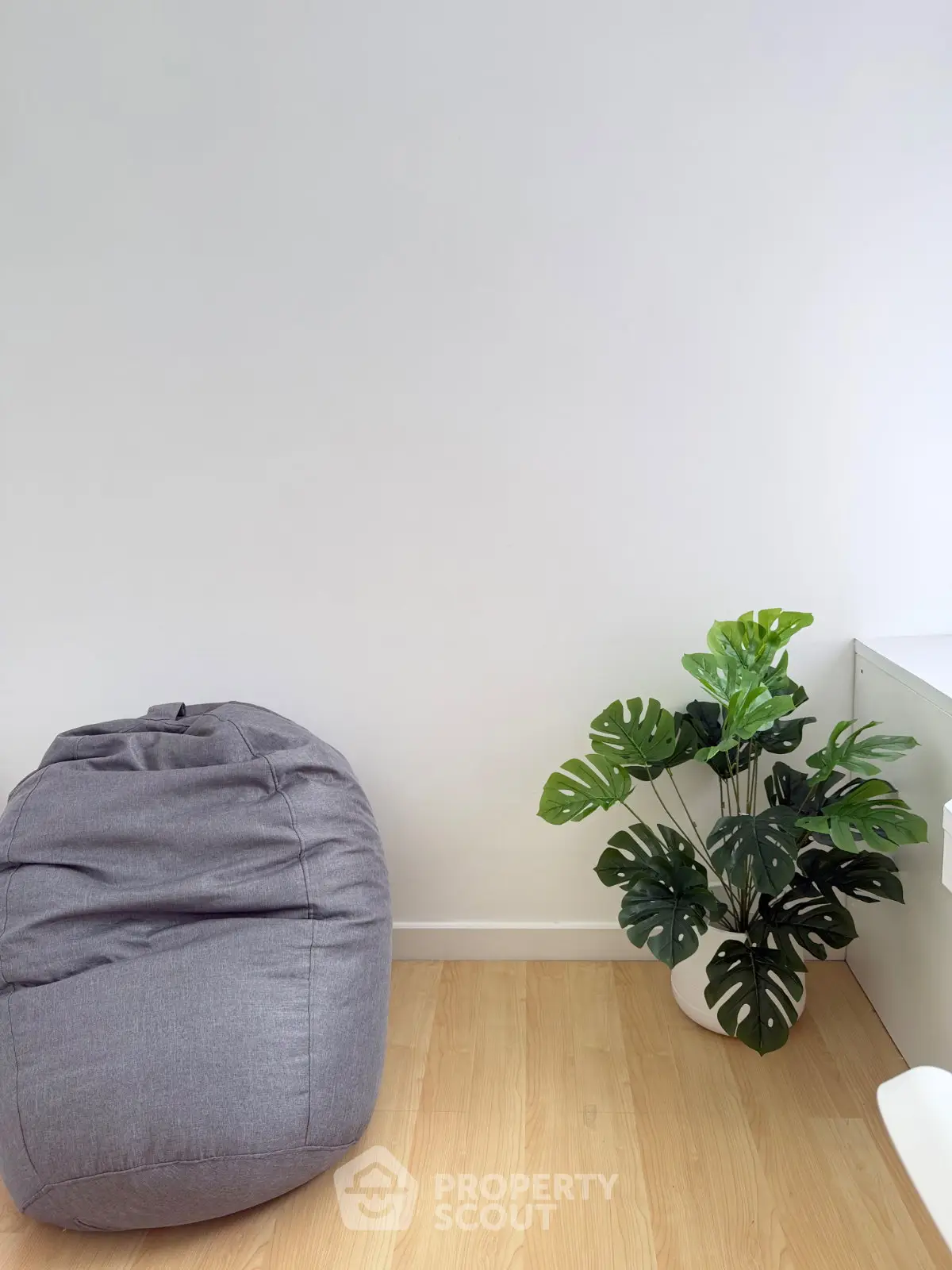 Minimalist interior with bean bag and potted plant on wooden floor