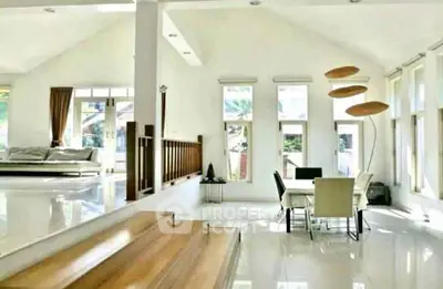 Spacious modern living room with dining area and large windows for natural light.