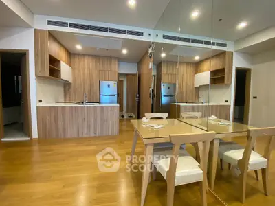 Modern open-layout kitchen and dining area with wooden flooring and mirrored wall