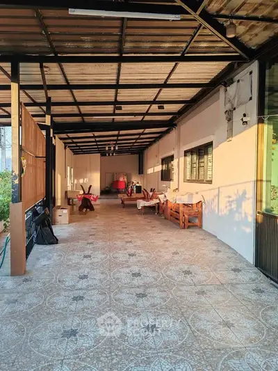 Spacious covered patio with tiled flooring and outdoor seating area.