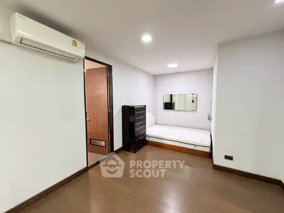 Spacious bedroom with modern air conditioning and wooden flooring