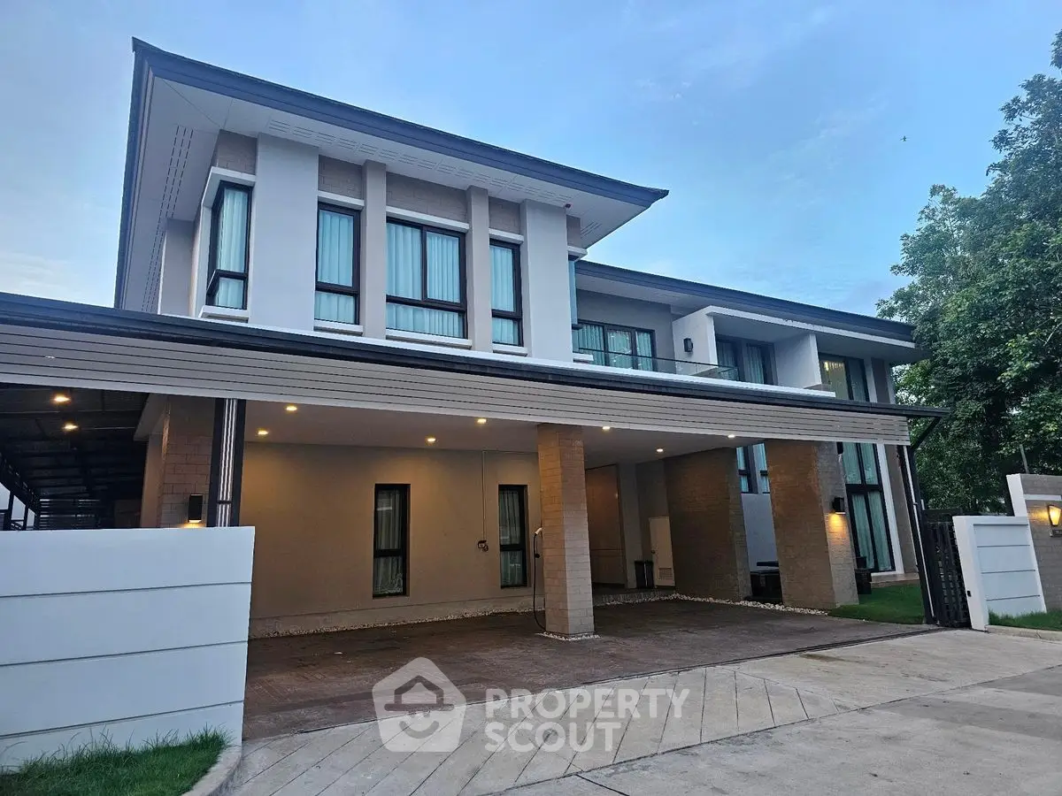 Modern two-story house with spacious driveway and sleek architectural design.
