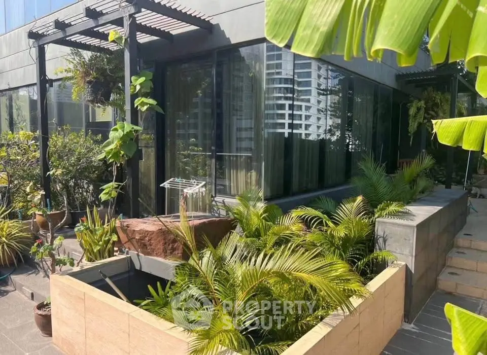 Modern building exterior with lush greenery and large windows, perfect for urban living.