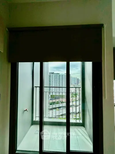 Modern apartment balcony with city view through glass doors