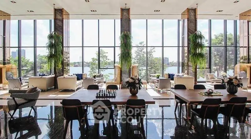 Luxurious lobby with floor-to-ceiling windows and stunning lake view, perfect for relaxation and social gatherings.