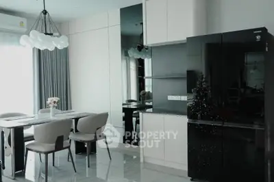 Modern dining area with sleek black refrigerator and elegant lighting