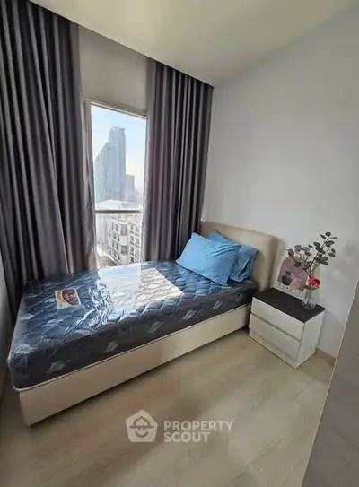Cozy bedroom with city view, featuring a single bed and modern decor, perfect for urban living.