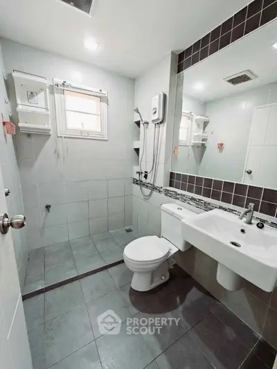Modern bathroom with sleek fixtures and large mirror in a contemporary home.