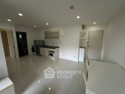 Modern apartment interior with sleek kitchen and washing machine, bright and spacious layout.