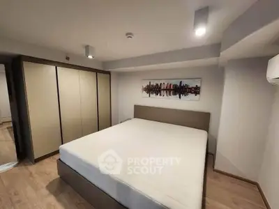 Spacious bedroom with modern decor and large wardrobe in a stylish apartment.