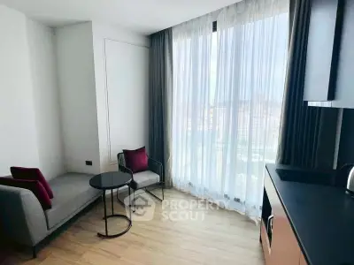 Modern living room with floor-to-ceiling window and stylish furniture