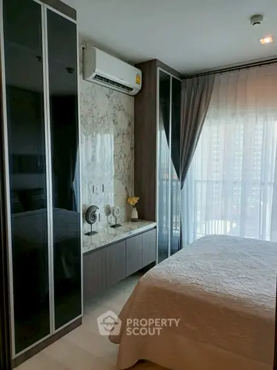 Modern bedroom with large windows and elegant decor in a high-rise apartment.
