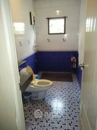 Charming bathroom with vibrant blue tiles and modern fixtures, perfect for a cozy home.